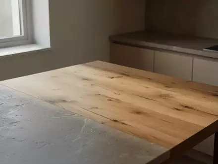 Eine minimalistische, ruhige Küchenumgebung mit Holztisch und natürlichem Lichteinfall. - Foto: über boerse-global.de