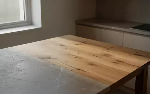 Eine minimalistische, ruhige Küchenumgebung mit Holztisch und natürlichem Lichteinfall. - Foto: über boerse-global.de