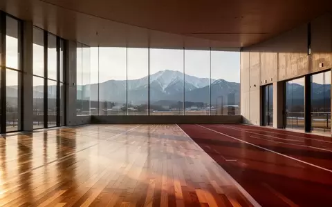 Eine moderne, leere Leichtathletik-Trainingsanlage in Aomori mit Blick auf die schneebedeckten Berge im Hintergrund. - Foto: über boerse-global.de