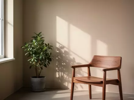 Ein minimalistisch eingerichteter, ruhiger Beratungsraum mit sanftem Tageslicht und einer Pflanze in einer Ecke. - Foto: ĂĽber boerse-global.de