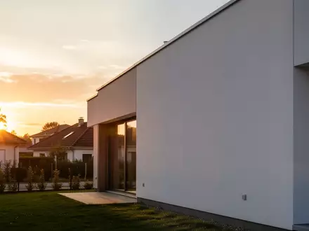 Ein modernes Einfamilienhaus in der Abenddämmerung, das die Umgebung für effizientes Heizen und Energiekosten verdeutlicht. - Foto: über boerse-global.de
