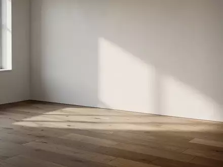 Ein minimalistischer, lichtdurchfluteter Raum mit sanften Schatten auf einem Holzboden, der eine ruhige und klare Atmosphäre ausstrahlt. - Foto: über boerse-global.de