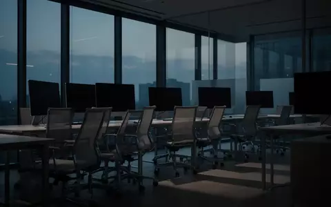 Ein unbesetzter, ruhig wirkender moderner Büroarbeitsplatz in der Dämmerung mit leeren Stühlen und ausgeschalteten Monitoren. - Foto: über boerse-global.de