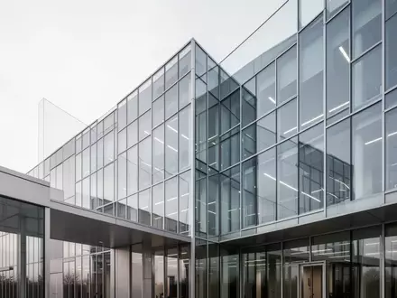 Ein modernes Bürogebäude aus Glas und Stahl bei Tageslicht. - Foto: über boerse-global.de