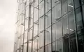 Moderne Glasfassade eines Bürogebäudes bei bewölktem Himmel - Foto: über boerse-global.de