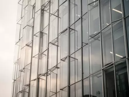 Moderne Glasfassade eines Bürogebäudes bei bewölktem Himmel - Foto: über boerse-global.de