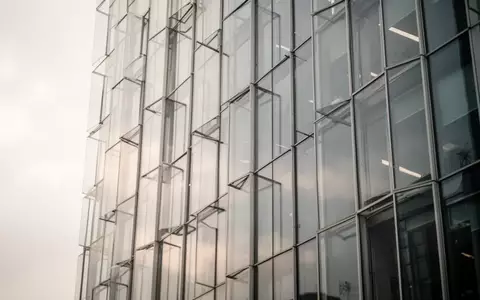Moderne Glasfassade eines Bürogebäudes bei bewölktem Himmel - Foto: über boerse-global.de