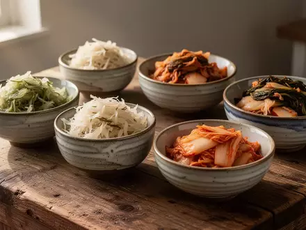 Traditionelle Keramikschalen mit fermentiertem Gemüse auf einem rustikalen Holztisch bei natürlichem Licht. - Foto: über boerse-global.de