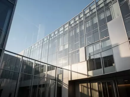 Moderne Glas- und Stahlfassade eines Regierungsgebäudes vor blauem Himmel - Foto: über boerse-global.de