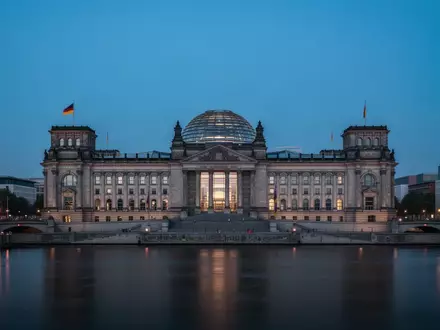 Das Reichstagsgebäude in Berlin bei Dämmerung, gesehen von der anderen Seite der Spree. - Foto: über boerse-global.de