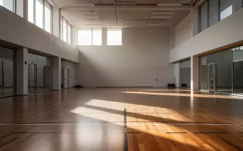 Ein minimalistischer, leerer Sportraum mit poliertem Holzboden und einfallendem Tageslicht. - Foto: über boerse-global.de