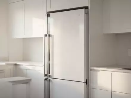 Eine moderne, aufgeräumte Küche mit einem geschlossenen Kühlschrank in einer hellen, minimalistischen Wohnumgebung. - Foto: über boerse-global.de