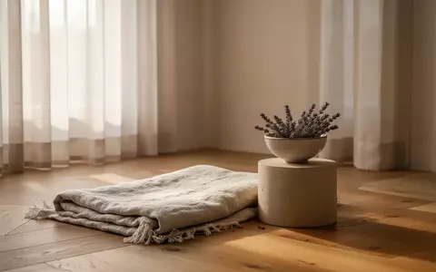 Ein minimalistischer, ruhiger Raum mit sanftem Tageslicht, einer gefalteten Decke und Lavendel, der eine Atmosphäre der Erholung ausstrahlt. - Foto: über boerse-global.de