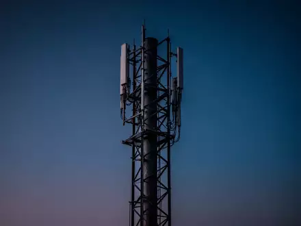Eine nächtliche Aufnahme eines Mobilfunkmastes vor einem dunklen Abendhimmel. - Foto: über boerse-global.de