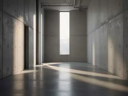 Ein minimalistischer, leerer Industrieflur mit Betonwänden und einfallendem Tageslicht. - Foto: über boerse-global.de