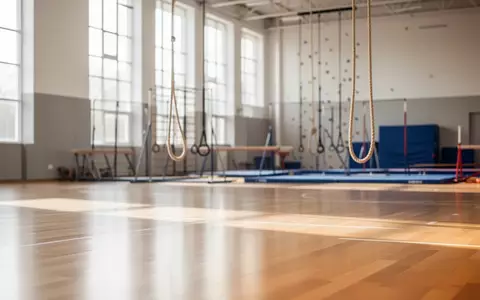 Helle, moderne Sporthalle mit Parkettboden und einfallendem Tageslicht, die eine Atmosphäre von Ruhe und Bewegung vermittelt. - Foto: über boerse-global.de