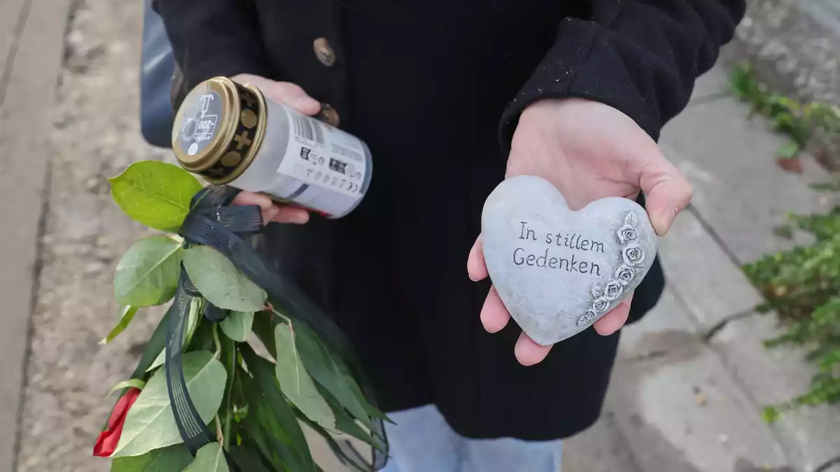 Eine Frau kommt mit Blumen zum Tatort. - Bild: Daniel Löb/dpa