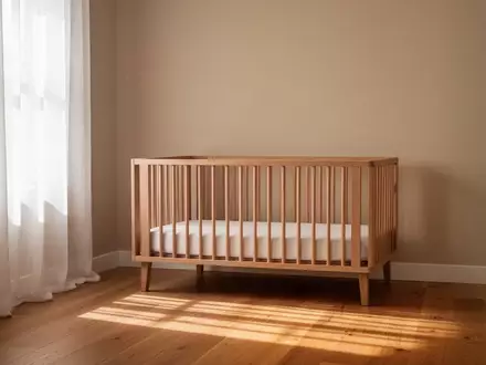 Ein ruhiges, minimalistisch eingerichtetes Kinderzimmer mit einem leeren Holzbett und weichem Tageslichteinfall. - Foto: über boerse-global.de