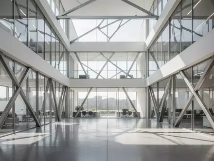Ein minimalistisches, lichtdurchflutetes Bürogebäude mit klaren Glaswänden und polierten Betonböden. - Foto: über boerse-global.de