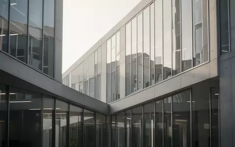 Moderne, minimalistische Fassade eines Bürogebäudes aus Glas und Beton bei Tageslicht. - Foto: über boerse-global.de