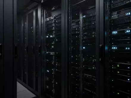 Dunkle, metallische Server-Racks in einem schattigen Rechenzentrum mit schwacher, kühler Beleuchtung. - Foto: über boerse-global.de