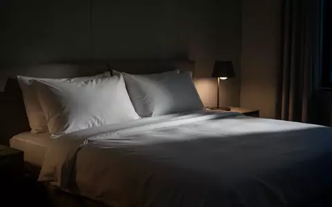 Ein minimalistisch eingerichtetes, in sanftes Licht getauchtes Schlafzimmer bei Nacht. - Foto: über boerse-global.de