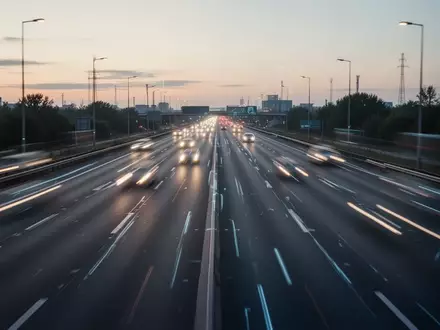 Eine leere, moderne Autobahn bei Dämmerung mit klaren Fahrbahnmarkierungen. - Foto: über boerse-global.de