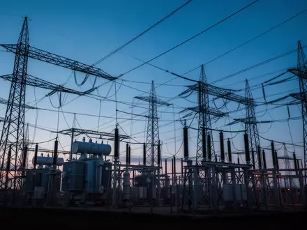 Ein Hochspannungsumspannwerk mit massiven Stahltürmen und Transformatoren in der Abenddämmerung. - Foto: über boerse-global.de