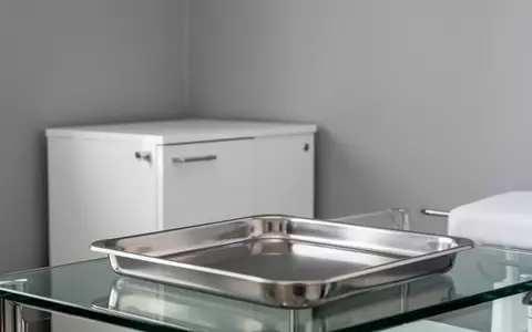 Ein minimalistischer, steriler Behandlungsraum mit einem leeren Edelstahltablett in einem neutralen, hellen Ambiente. - Foto: über boerse-global.de