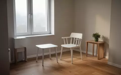 Ein leerer, ruhig gestalteter Therapieraum mit einem weißen Stuhl und einer Pflanze vor einem hellen Fenster. - Foto: über boerse-global.de