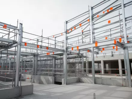 Moderne industrielle Baustelle mit Stahlgerüsten und Sicherheitsmarkierungen in einer klaren, sachlichen Umgebung. - Foto: über boerse-global.de
