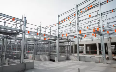 Moderne industrielle Baustelle mit Stahlgerüsten und Sicherheitsmarkierungen in einer klaren, sachlichen Umgebung. - Foto: über boerse-global.de