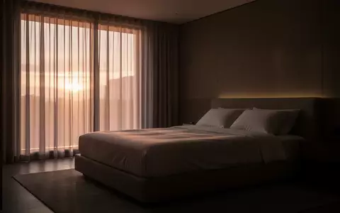 Ein minimalistisch eingerichtetes, ruhiges Schlafzimmer bei Tagesanbruch mit unbenutztem, ordentlich gemachtem Bett. - Foto: über boerse-global.de