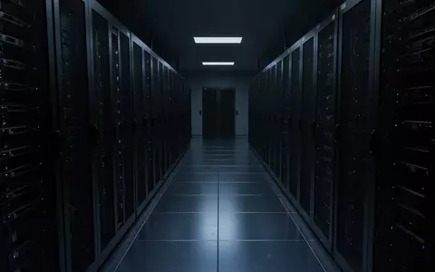 Ein dunkler, moderner Serverraum mit metallischen Bodenplatten und leeren Serverschränken in kühlem blauen Licht. - Foto: über boerse-global.de