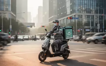 Ein Lieferfahrer auf einem Elektroroller in einer chinesischen Großstadt bei Tageslicht. - Foto: über boerse-global.de