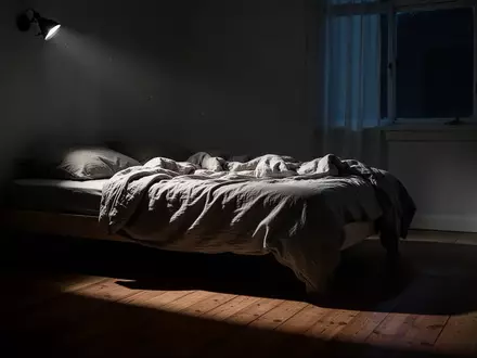 Ein ungemachtes Bett in einem spärlich beleuchteten Schlafzimmer bei Nacht mit sanftem Mondlichteinfall. - Foto: über boerse-global.de