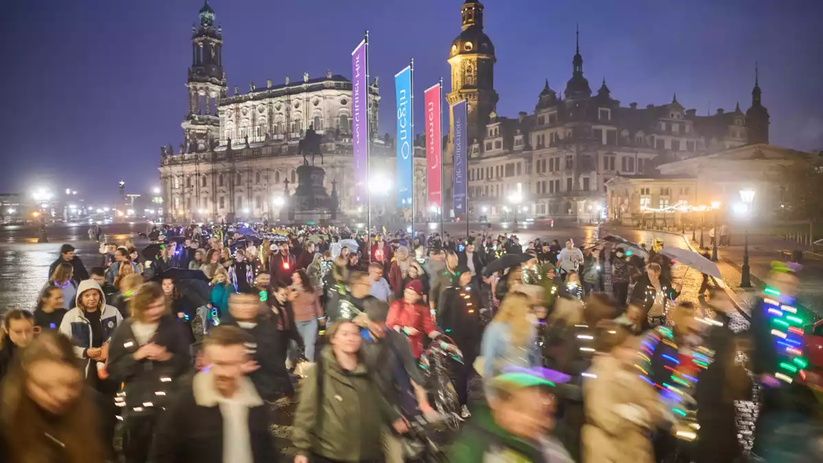 Teilnehmer des Spazierclubs laufen am Abend durch Dresden. - Bild: Robert Michael/dpa