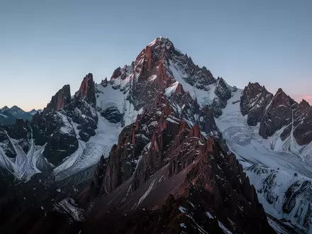 Eine raue, schneebedeckte Bergspitze in den Anden unter einem klaren, kalten Dämmerungshimmel. - Foto: über boerse-global.de