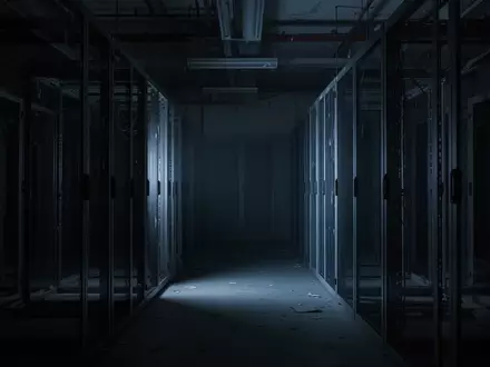 Ein dunkler, leerer Serverraum mit metallischen Regalen in kĂĽhlem, blauem Licht. - Foto: ĂĽber boerse-global.de