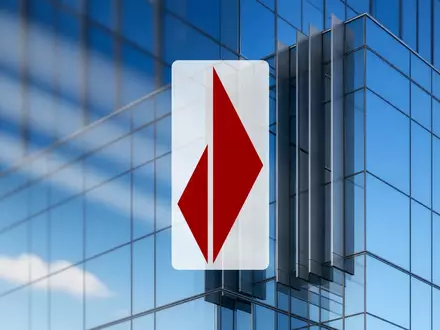 Moderne Glasfassade eines Bankgebäudes bei klarem Himmel als Symbol für Finanzwesen und Marktstabilität. - Foto: über boerse-global.de