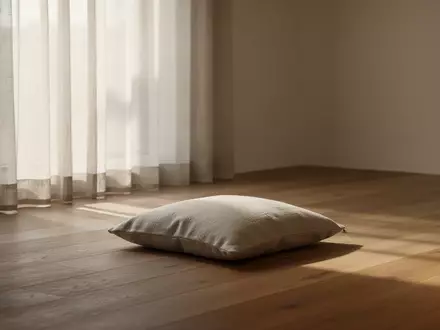 Ein minimalistischer, lichtdurchfluteter Raum mit einem einzelnen Sitzkissen auf einem Holzboden als Symbol für Achtsamkeit. - Foto: über boerse-global.de