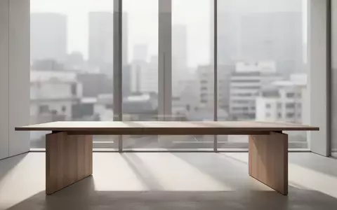 Ein minimalistischer, moderner Arbeitsplatz mit einem leeren Holztisch in einem hellen, architektonisch gestalteten Raum. - Foto: über boerse-global.de