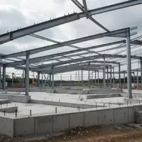 Eine leere Baustelle mit Stahlträgern und Betonfundamenten unter einem bewölkten Himmel. - Foto: über boerse-global.de
