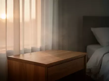 Ein ruhiges, minimalistisches Schlafzimmer bei Tagesanbruch, das eine Atmosphäre der Erholung und nächtlichen Regeneration vermittelt. - Foto: über boerse-global.de