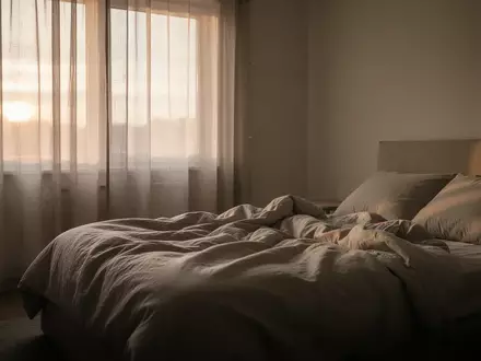 Ein minimalistisch eingerichtetes Schlafzimmer bei Tagesanbruch, das eine ruhige und erholsame Atmosphäre vermittelt. - Foto: über boerse-global.de