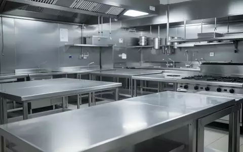 Eine leere, sterile Edelstahl-Großküche mit sauberen Arbeitsflächen und professioneller Küchenausstattung. - Foto: über boerse-global.de