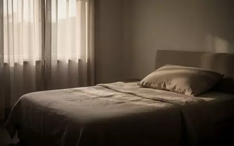 Ein schlichtes, ruhig wirkendes Schlafzimmer bei morgendlichem Licht mit einem unbenutzten, ordentlich gemachten Bett. - Foto: über boerse-global.de