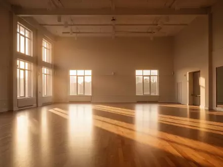Ein heller, leerer Tanzsaal mit poliertem Holzboden und einfallendem Sonnenlicht am späten Nachmittag. - Foto: über boerse-global.de