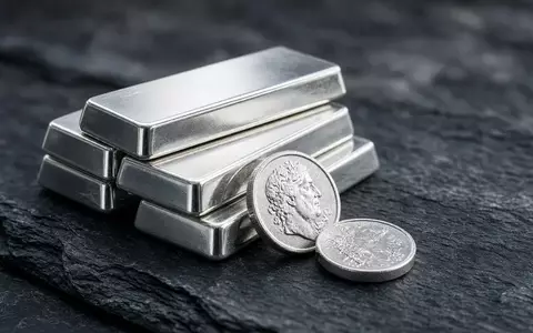 Polierte Silberbarren und Münzen auf einer dunklen Schieferplatte bei natürlichem Licht. - Foto: über boerse-global.de
