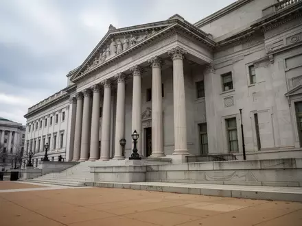 Die steinerne Fassade eines neoklassizistischen Regierungsgebäudes in Washington, D.C. bei bewölktem Himmel. - Foto: über boerse-global.de